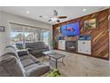 Comfortable living room with a fireplace, wood accent wall, and sliding glass doors to the pool area at 1223 Casa Palermo Cir, Henderson, NV 89011