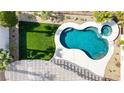 Aerial view of a private kidney-shaped pool and spa surrounded by lush landscaping at 1223 Casa Palermo Cir, Henderson, NV 89011