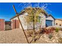 Front corner view of desert home, featuring a 3 car garage and gated side yard at 1580 S Outlaw St, Pahrump, NV 89060