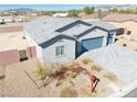 New home featuring desert landscaping, three car garage, and a gray exterior paint at 1580 S Outlaw St, Pahrump, NV 89060