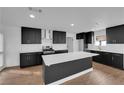 A modern kitchen featuring black cabinets, stainless steel appliances, and a bright white island at 2058 Citroen St, Las Vegas, NV 89142