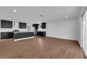 Open-concept kitchen with dark cabinets, a center island, and wood-look flooring at 2058 Citroen St, Las Vegas, NV 89142