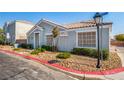 Neutral colored one-story home with desert landscaping, and covered front entry at 2510 Influential Ct, North Las Vegas, NV 89031