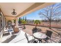 Inviting covered patio featuring outdoor seating, ceiling fan, and desert landscaping at 2633 Flare Star Dr, Henderson, NV 89044