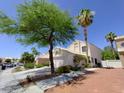 Beautiful home featuring a manicured yard, tall palm tree, desert landscaping, and attached two-car garage at 326 Lander Dr, Henderson, NV 89074