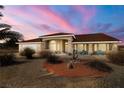 Charming single-story home featuring a low-maintenance xeriscape front yard and a terracotta tile roof at dusk at 3430 Flagstone Ct # 2, Pahrump, NV 89048