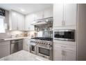 Modern kitchen featuring stainless steel appliances, sleek white cabinets, and granite countertops at 4746 Rosalie Cir, North Las Vegas, NV 89031