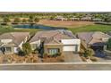 Aerial view of a single-Gathering home with a tile roof, a two-car garage, desert landscaping, and a beautiful golf course view at 4775 E Beacon Ridge Dr, Pahrump, NV 89061