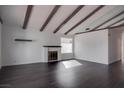 Spacious living room features a white-brick fireplace, wood flooring, and vaulted ceilings with wood beams at 4775 Monaco Rd, Las Vegas, NV 89121