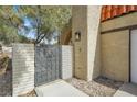 Inviting entrance with brick accent wall, wrought iron gate, and desert landscaping at 5102 Tennis Ct, Las Vegas, NV 89120