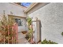 Inviting entrance with a stucco wall, cactus accent, and a charming pink gate leading to the front door at 5185 Briar Meadow Way, Las Vegas, NV 89118