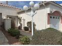 Inviting front entrance with a decorative light post, mature landscaping, and white painted stucco at 5185 Briar Meadow Way, Las Vegas, NV 89118