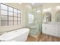 Luxurious bathroom featuring a soaking tub, a glass-enclosed shower, and elegant fixtures at 5520 Cranwood Ct, Las Vegas, NV 89130