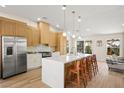 Stylish kitchen featuring a waterfall island with seating, stainless steel appliances, and wood cabinets at 5520 Cranwood Ct, Las Vegas, NV 89130