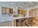 Modern kitchen with island seating, pendant lighting, stainless appliances and stylish cabinetry at 6009 Silvalde Ln, Las Vegas, NV 89135