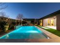 Backyard pool area at twilight with modern pergola, outdoor kitchen and manicured landscaping at 6009 Silvalde Ln, Las Vegas, NV 89135