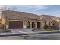 Beautiful home exterior showcasing a spacious three car garage, tile roof, and desert landscaping at 6021 Vista Clara St, Las Vegas, NV 89148