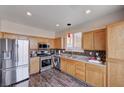 Updated kitchen features stainless steel appliances, light wood cabinetry, and mosaic backsplash at 608 Breezy Sage Ct, Henderson, NV 89015