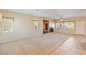 Spacious living room with plush carpet, a ceiling fan, and a cozy fireplace feature at 6337 Black Mane Way, North Las Vegas, NV 89081