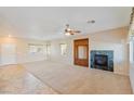 Bright living room featuring a fireplace, ceiling fan, and tile/carpet flooring at 6337 Black Mane Way, North Las Vegas, NV 89081