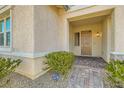 Close-up view of the front door entry, surrounded by lush shrubbery and a charming brick walkway at 668 Look Lively Ct, Henderson, NV 89011