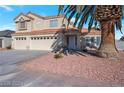 This lovely two-story home boasts a three-car garage and mature landscaping, including a large palm tree at 7400 Wheat Grass Ct, Las Vegas, NV 89129