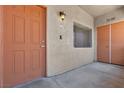 Inviting condo entrance featuring a solid front door, exterior lighting, and unit number 102 at 7701 W Robindale Rd # 102, Las Vegas, NV 89113