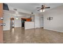 Open-concept living room with tile flooring, a ceiling fan, seamlessly flowing into the kitchen at 7701 W Robindale Rd # 102, Las Vegas, NV 89113