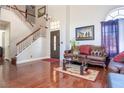 Inviting living room boasts hardwood floors, staircase, and a comfortable leather sofa, creating a welcoming atmosphere at 8262 Huxley St, Las Vegas, NV 89123