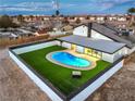 Aerial of backyard oasis with a modern pool, artificial turf, and privacy fencing for outdoor enjoyment at 8645 Edmond St, Las Vegas, NV 89139