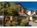 Two story home with neutral stucco, two car garage, and desert landscaping at 8699 Grand Sequoia St, Las Vegas, NV 89139