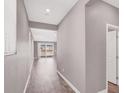 Bright hallway featuring modern gray walls and stylish wood-look floors leading to a sunny living area at 9330 Brookmont Ave, Las Vegas, NV 89149