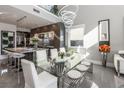 A bright and airy dining area featuring modern lighting and a glass table at 10605 Harvest Green Way, Las Vegas, NV 89135