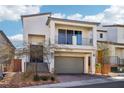 Beautiful two-story home featuring a balcony, gray garage door, and low maintenance landscaped front yard at 10801 Far Country Ave, Las Vegas, NV 89129