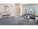 Spacious living room with a decorative piano, modern sofa, and a bright window with plantation shutters at 2045 Summit Pointe Dr, Las Vegas, NV 89117