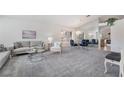 Bright living room featuring a gray sofa set, elegant glass coffee table, and decorative art at 2045 Summit Pointe Dr, Las Vegas, NV 89117