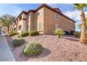 View of a well-maintained condo featuring neat landscaping and a desert rock garden on a sunny day at 231 W Horizon Ridge Pkwy # 2413, Henderson, NV 89012