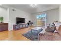 Cozy living room with hardwood floors, a comfortable sofa, and a sliding glass door to a balcony at 231 W Horizon Ridge Pkwy # 2413, Henderson, NV 89012