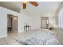 Open-concept living room with tile flooring, ceiling fan, and neutral color palette at 3531 Barrel Bronco Ct, North Las Vegas, NV 89032