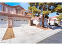 Charming two-story home showcasing a three-car garage, complemented by mature trees and a meticulously maintained driveway at 4451 Tomer Ln, Las Vegas, NV 89121