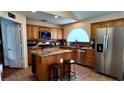 Bright kitchen with stainless steel appliances, granite countertops, tile backsplash, central island, and wooden cabinets at 6545 Bradford Ln, Las Vegas, NV 89108