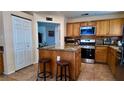 Kitchen featuring wooden cabinets, granite countertops, and a center island with seating at 6545 Bradford Ln, Las Vegas, NV 89108