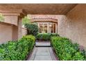 Landscaped courtyard entrance featuring lush greenery, a tiled walkway, and a glimpse of the home's interior at 7607 Boca Raton Dr, Las Vegas, NV 89113