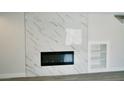 Close up of the fireplace with built-in shelving on a marble accent wall at 7808 Wavering Pine Dr, Las Vegas, NV 89143