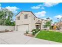 Inviting two-story home with lush green front lawn, desert landscaping, and attached garage at 8324 Shark Tank Ct, Las Vegas, NV 89128