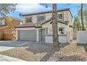 Two-story home with gray garage door and desert landscaping at 8979 Green Jade Dr, Las Vegas, NV 89129