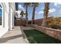 Home featuring backyard area with trees and a low brick retaining wall at 924 Angel Star Ln, Las Vegas, NV 89145