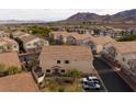 Aerial view of a neighborhood with similar townhomes, street, and cars parked with desert mountains in the background at 1292 Large Cap Dr # 3, Henderson, NV 89074