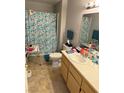 Cozy bathroom features a shower with floral curtain, toilet, and vanity with single sink at 1881 W Alexander Rd # 1035, North Las Vegas, NV 89032