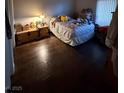 Bedroom with wood floors, a bed, window blinds, and vintage lamp providing soft lighting at 1881 W Alexander Rd # 1035, North Las Vegas, NV 89032